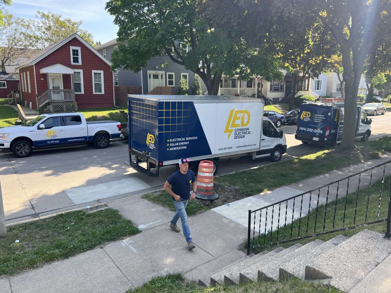 Lehmann Electrical team working in New Berlin neighborhood with service trucks and residential homes