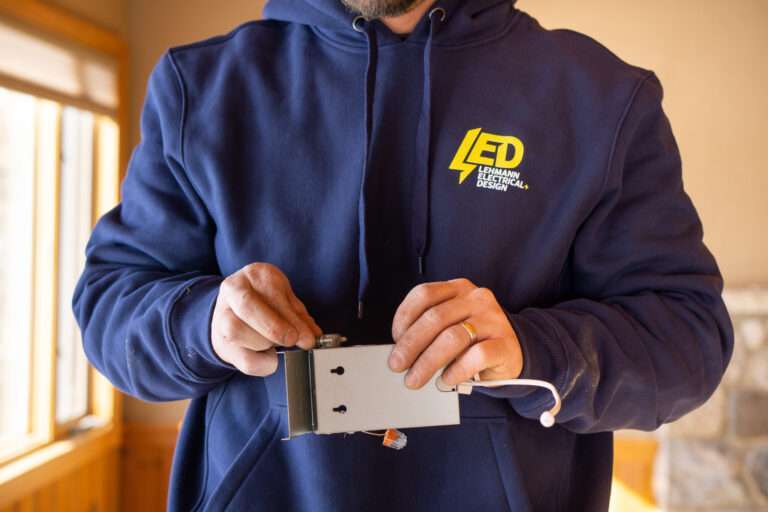 Lehmann electrician holding the junction box for a slim LED recessed light