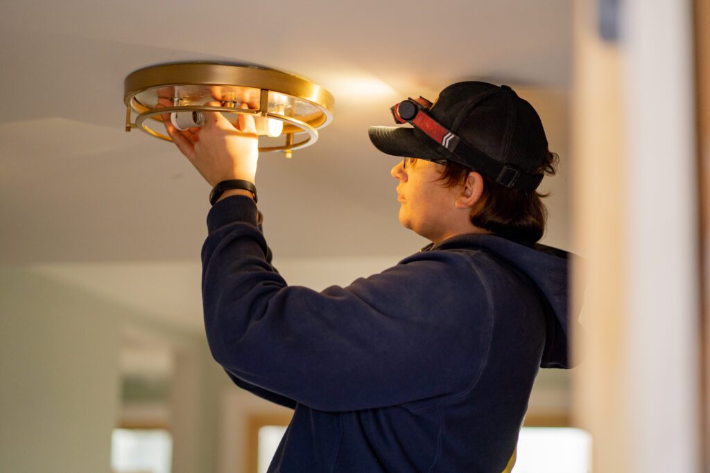 Electrician installing a ceiling light fixture