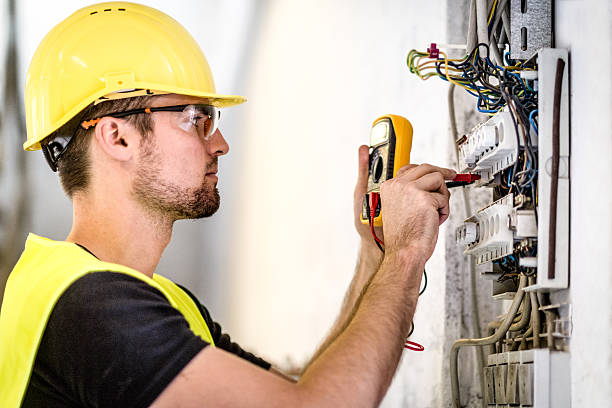 Electrician testing voltage at electrical panel with multimeter