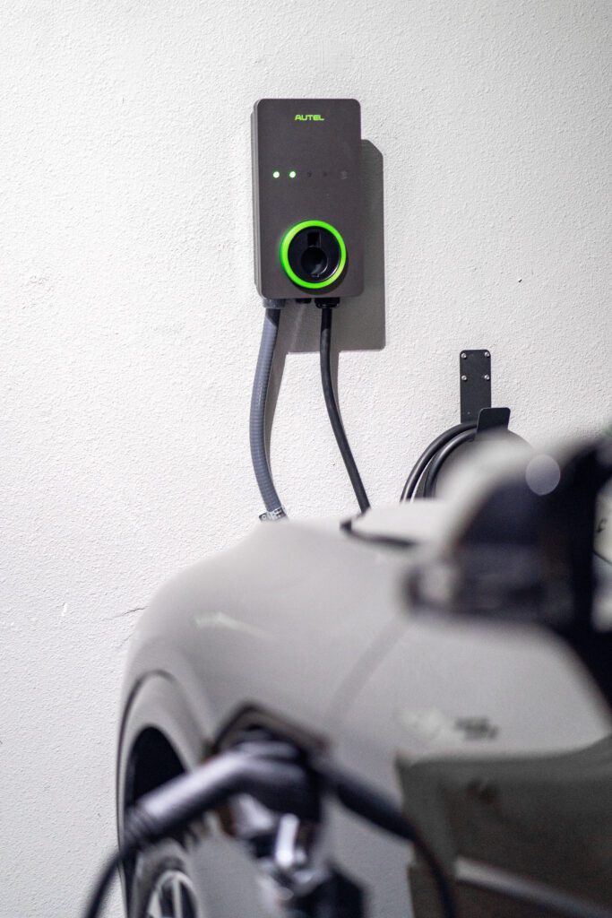 Autel wall-mounted EV charger with green illuminated ring installed on residential interior wall