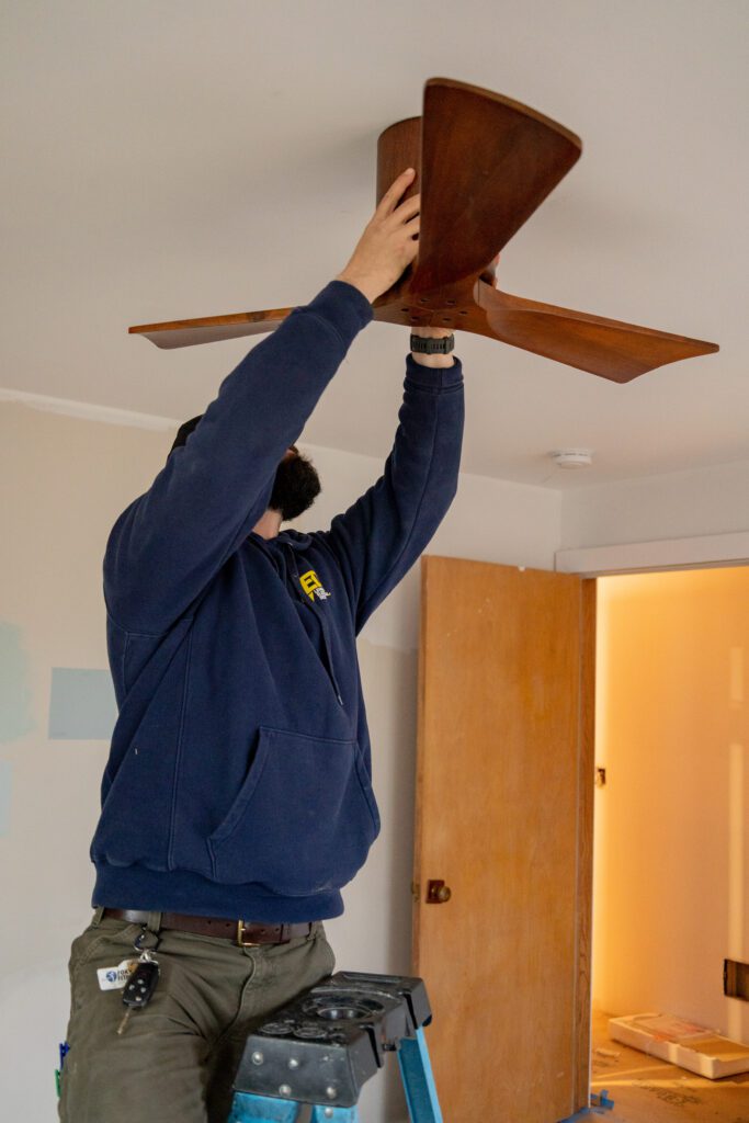 Electrician mounting a ceiling fan