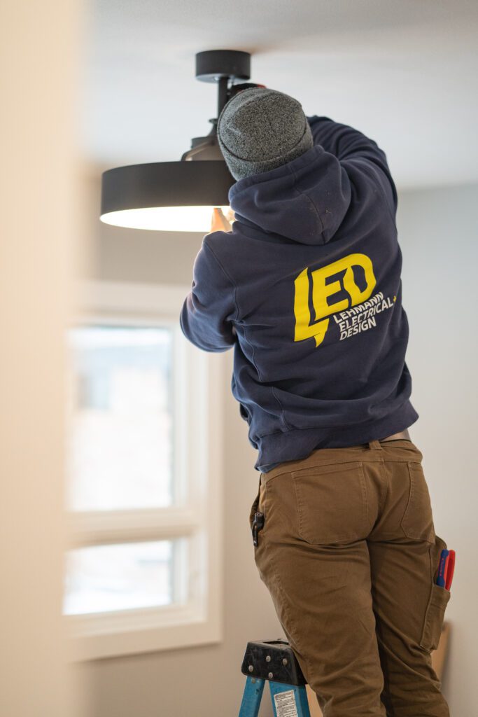 Electrician installing a ceiling fan