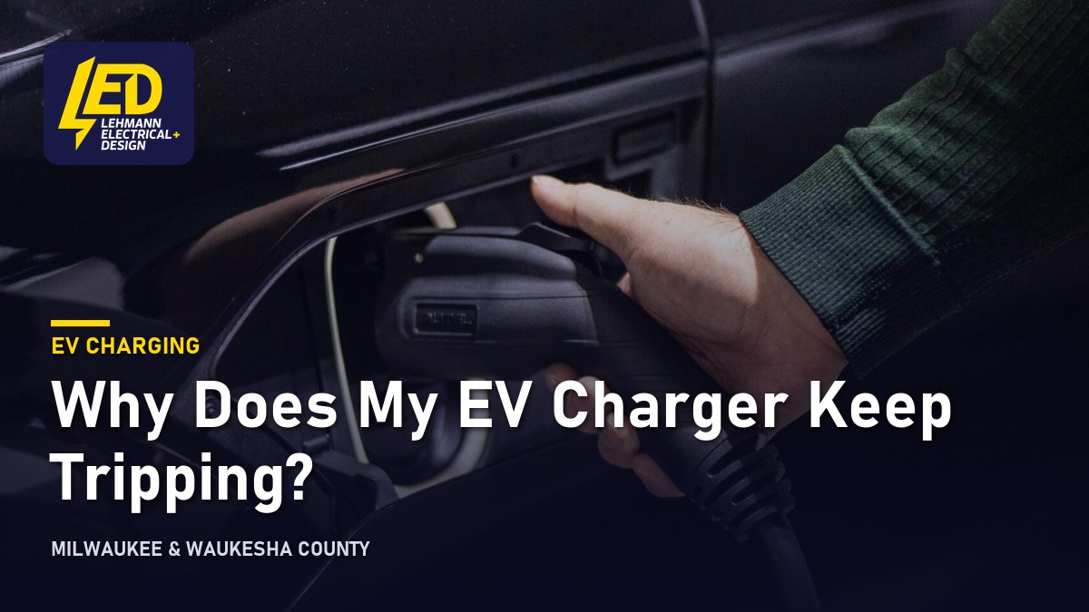 Hand plugging a charging cable into an electric car, titled Why Does My EV Charger Keep Tripping?