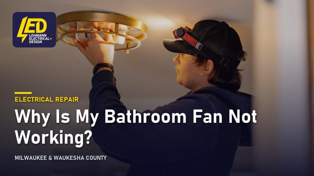 Electrician reaching up to work on a ceiling fixture, titled Why Is My Bathroom Fan Not Working?