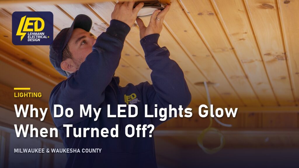 Electrician installing a recessed LED ceiling light, titled Why Do My LED Lights Glow When Turned Off?