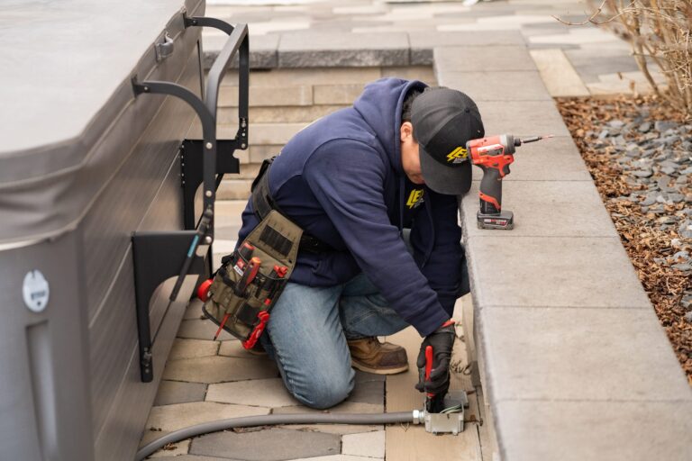Lehmann Electrical technician installing an outdoor electrical outlet on a residential deck railing