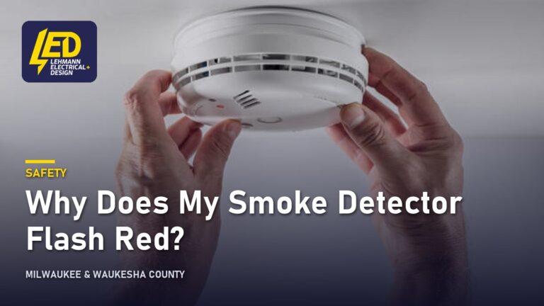 Hands installing a white circular smoke detector into a ceiling, titled Why Does My Smoke Detector Flash Red?